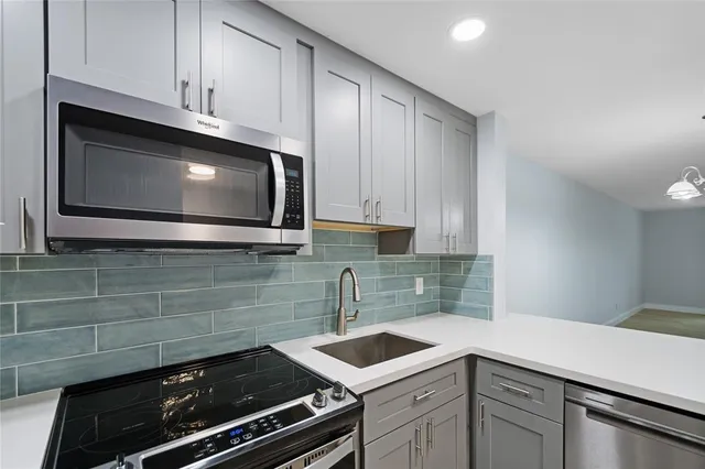 a kitchen with stainless steel appliances a stove a microwave sink and cabinets