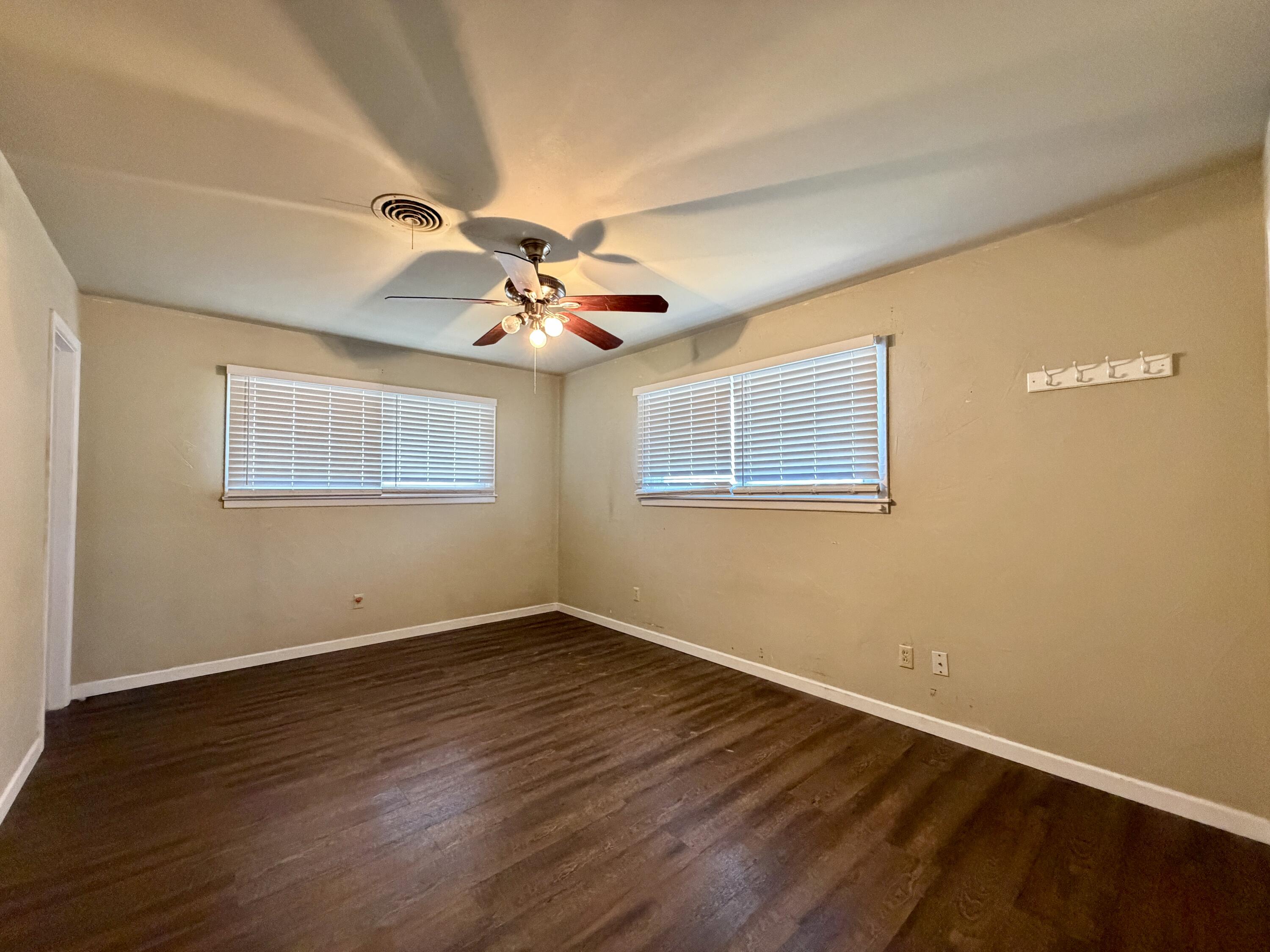4401 28th Street Lubbock, TX 79410 - Photo 12 of 25 a view of an empty room with wooden floor and a window