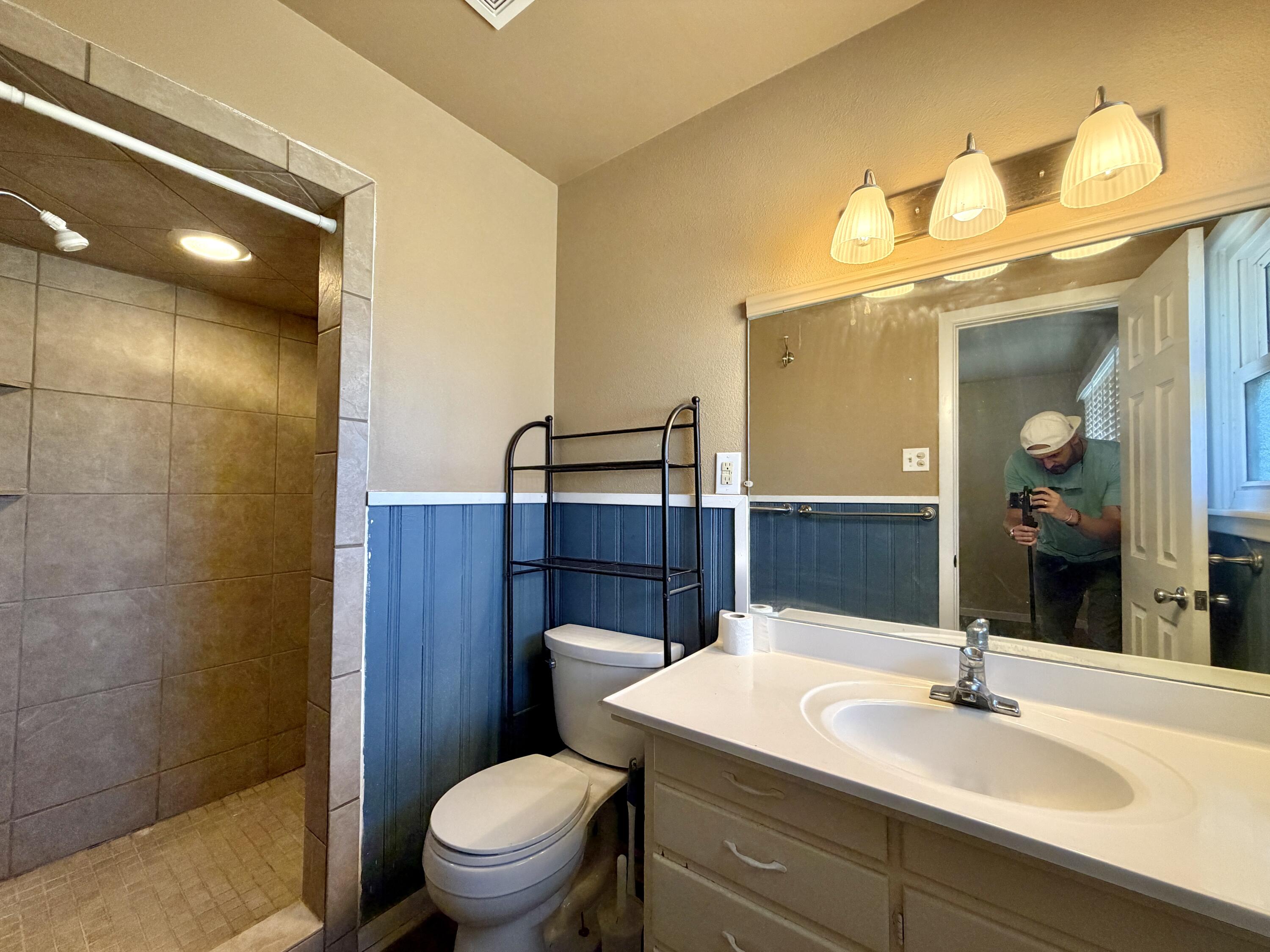 4401 28th Street Lubbock, TX 79410 - Photo 15 of 25 a bathroom with a sink a toilet a mirror and shower