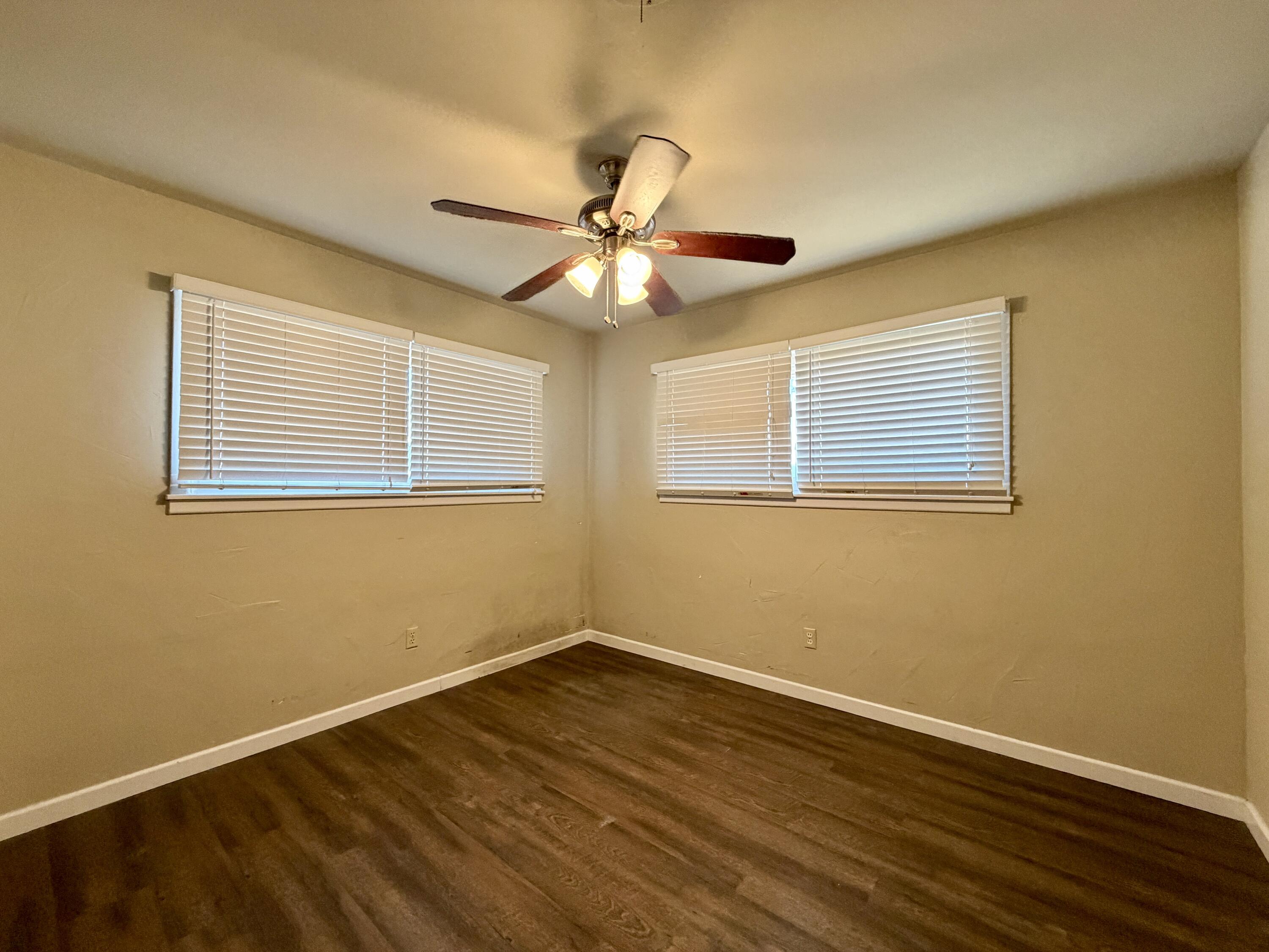 4401 28th Street Lubbock, TX 79410 - Photo 17 of 25 a view of a room with wooden floor and a ceiling fan