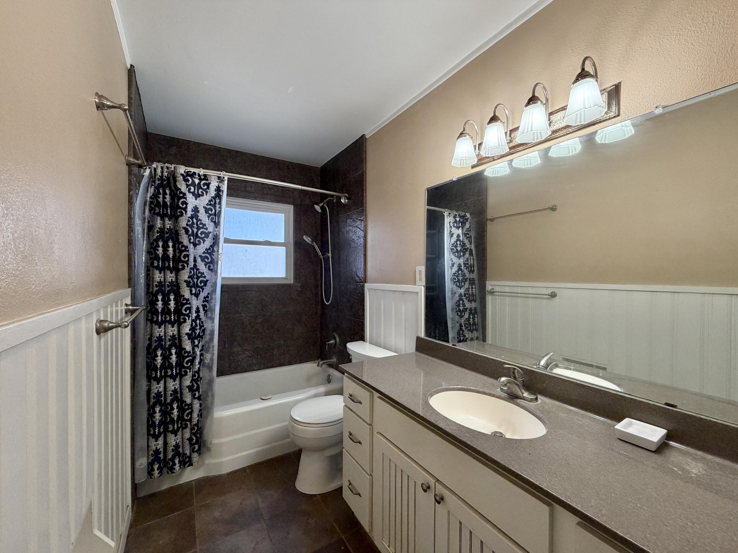 4401 28th Street Lubbock, TX 79410 - Photo 19 of 25 a bathroom with a sink a toilet a tub and shower