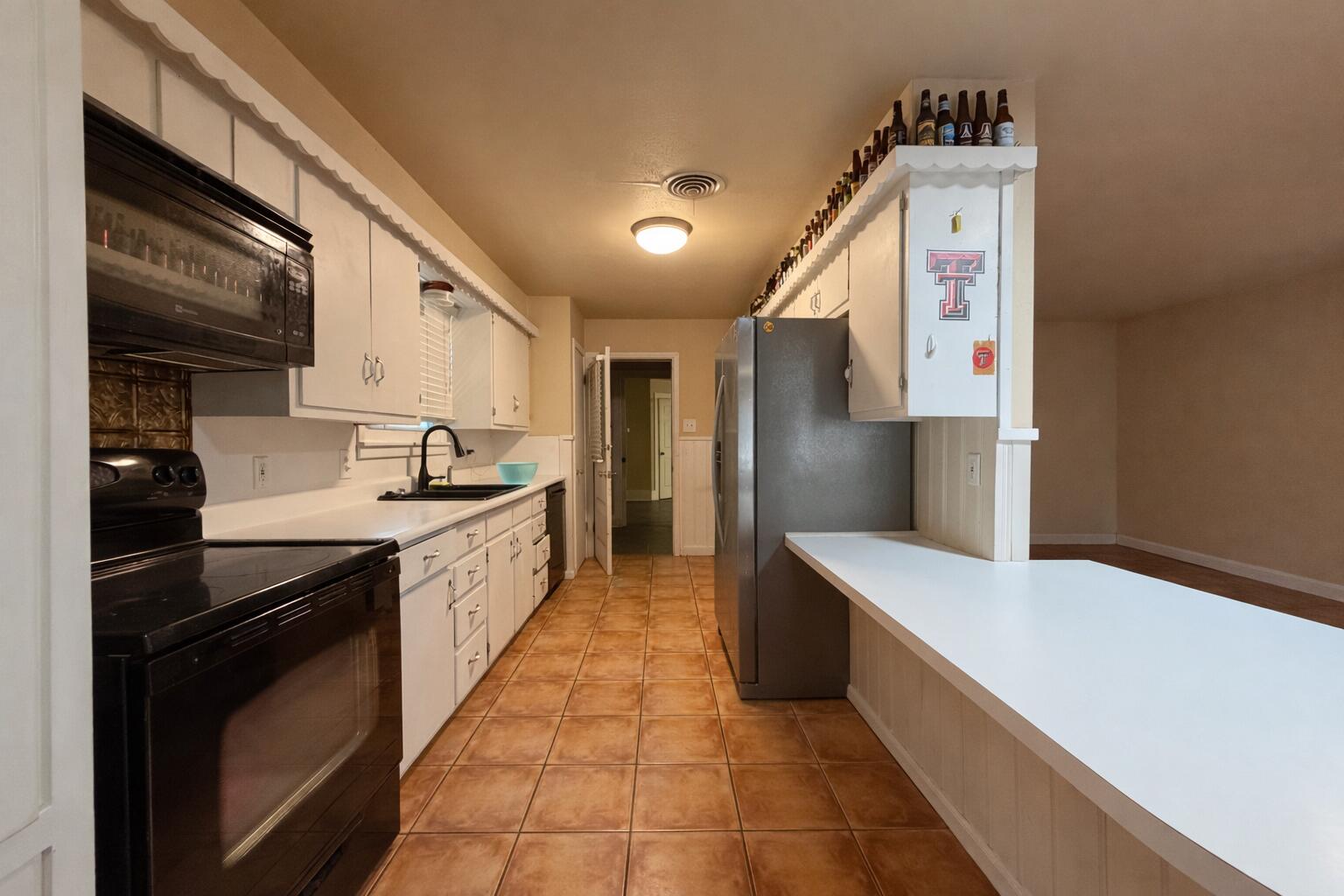 4401 28th Street Lubbock, TX 79410 - Photo 7 of 25 a large kitchen with stainless steel appliances lots of counter space and wooden floor
