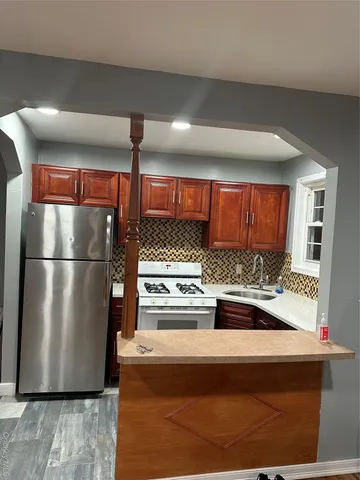 a kitchen with stainless steel appliances granite countertop a refrigerator and a stove