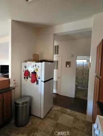 a white refrigerator freezer and a stove sitting inside of a room