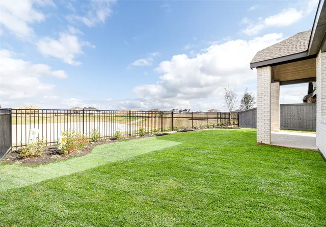 a view of a house with a yard and a large tree