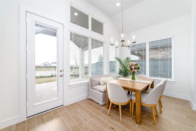 a dining room with furniture a chandelier and wooden floor