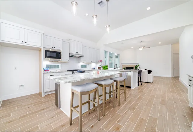 a kitchen with stainless steel appliances kitchen island granite countertop a sink and cabinets