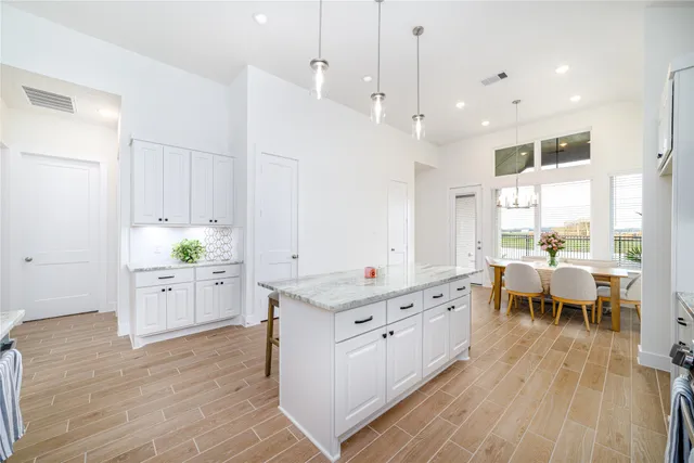 a large white kitchen with lots of counter space and a wooden floors
