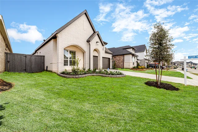 a front view of a house with a yard and trees