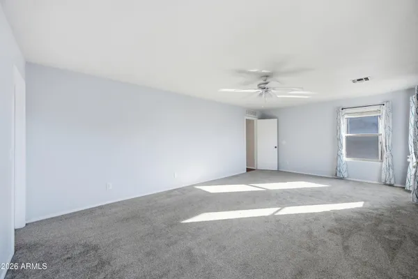 a view of an empty room with window and closet area