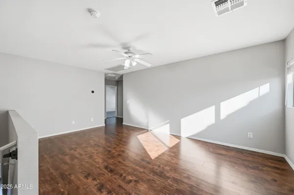 an empty room with closet and a chandelier fan