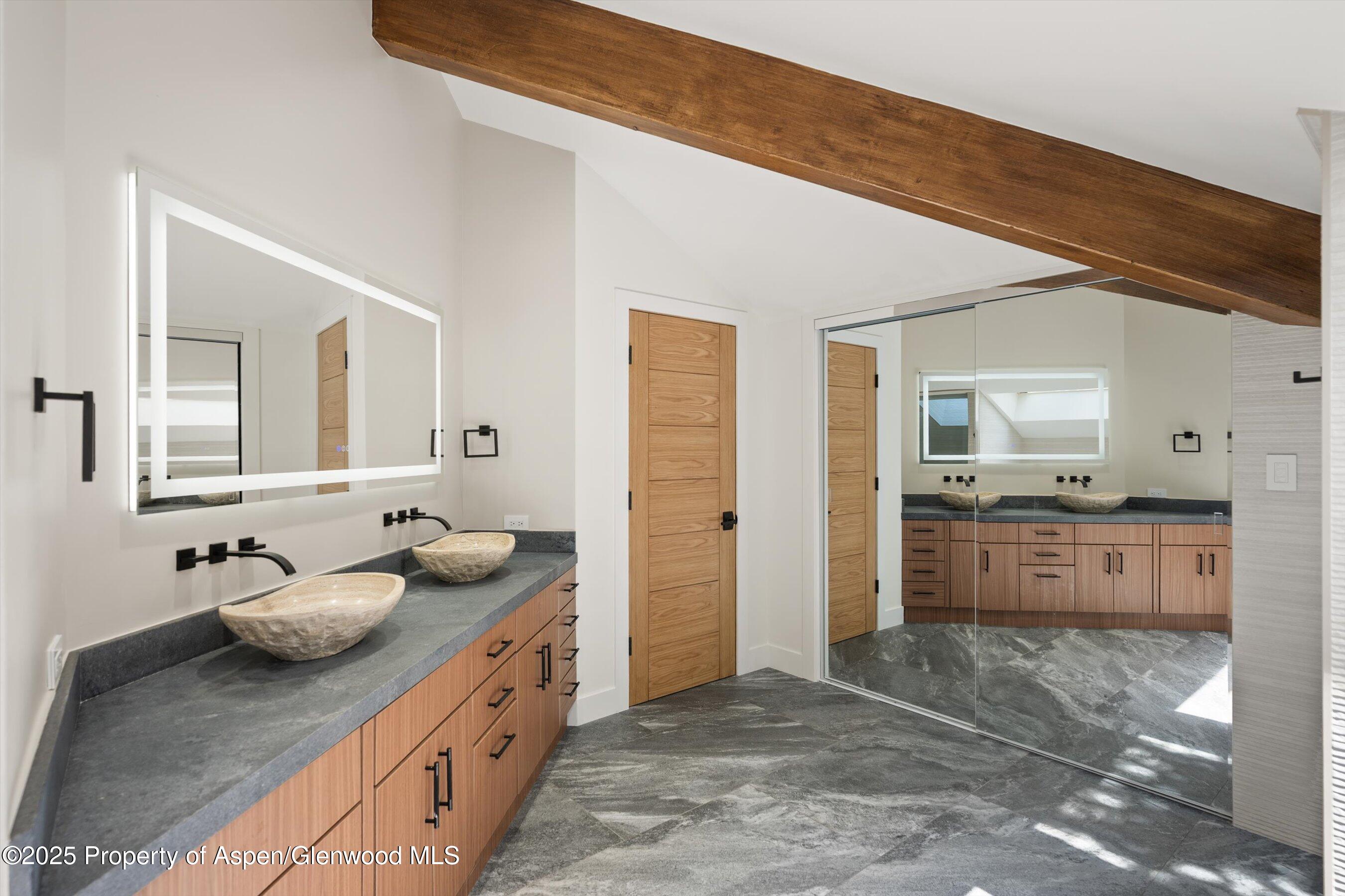 75 Bennett Court Aspen, CO 81611 - Photo 25 of 65 a bathroom with a granite countertop sink and a mirror