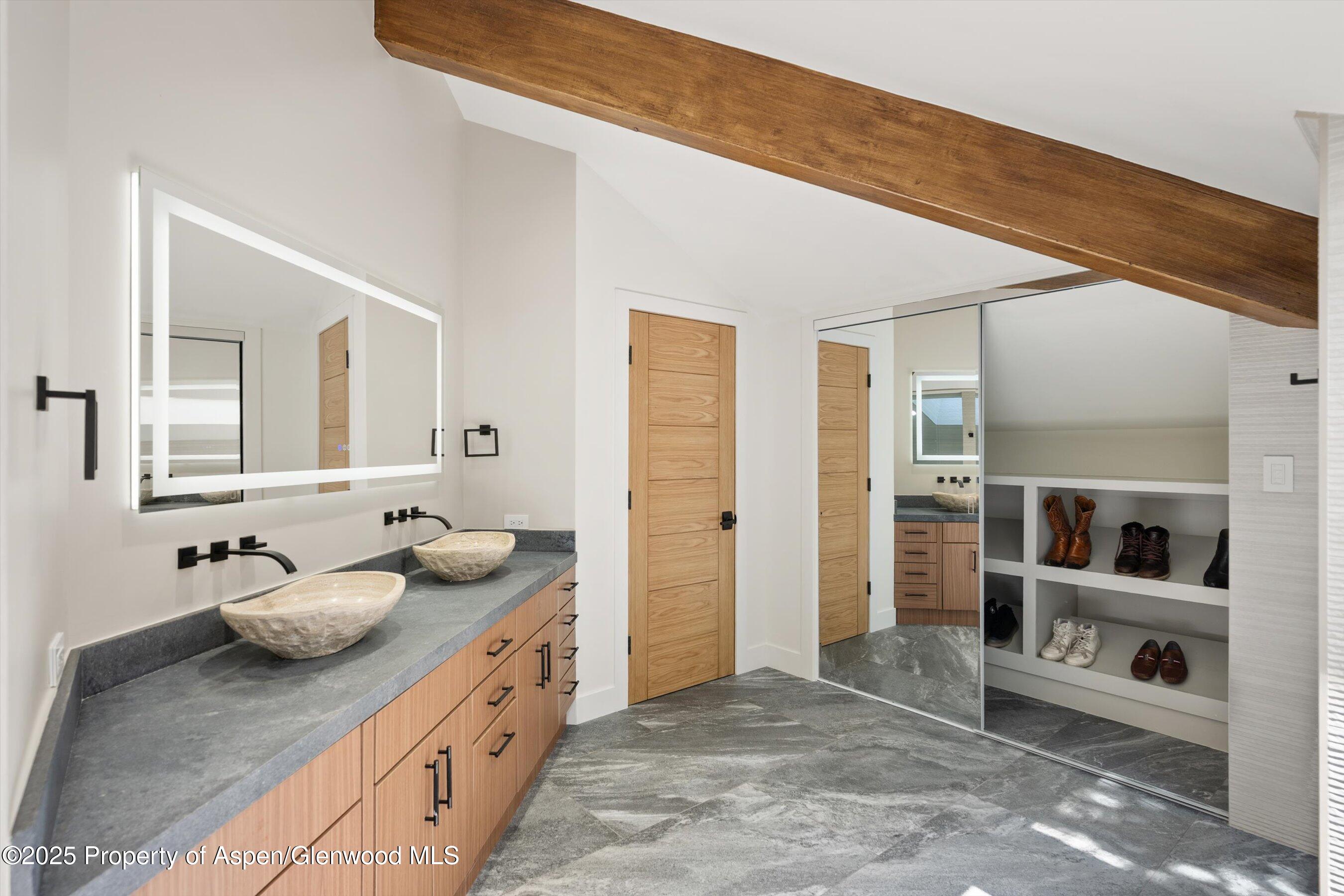 75 Bennett Court Aspen, CO 81611 - Photo 26 of 65 a bathroom with a granite countertop sink and a mirror