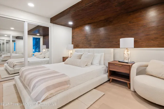 a view of a patio with couches table and chairs with potted plants and large trees