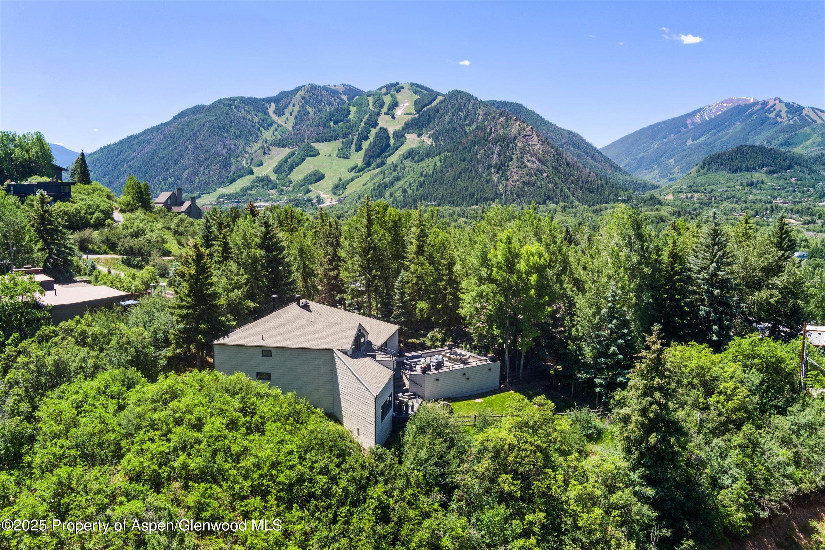 75 Bennett Court Aspen, CO 81611 - Photo 56 of 65 a view of a house with a mountain and a forest