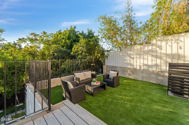 a view of backyard with seating space and trees