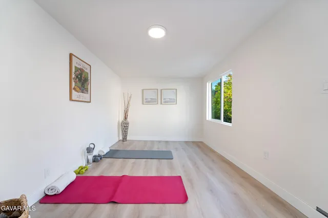 a living room with a bed and a wooden floor