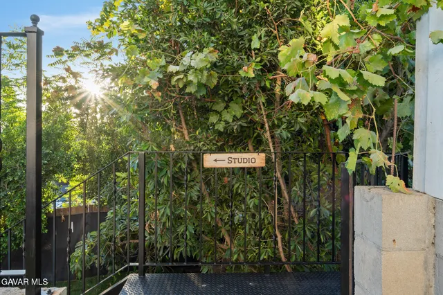 a sign that is sitting in front of a tree