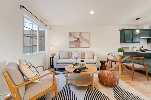 a living room with furniture a rug and a window