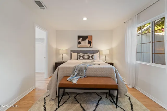 a bedroom with a bed and wooden floor