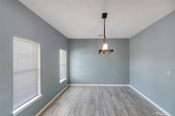 a view of an empty room with wooden floor and a fireplace