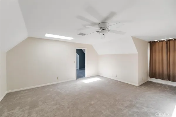 a view of an empty room with closet and a chandelier fan