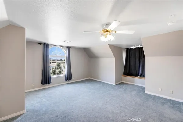 an empty room with closet and a chandelier fan