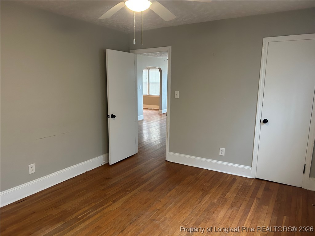 1700 Cedar Creek Road Fayetteville, NC 28312 - Photo 16 of 31 an empty room with wooden floor and chandelier