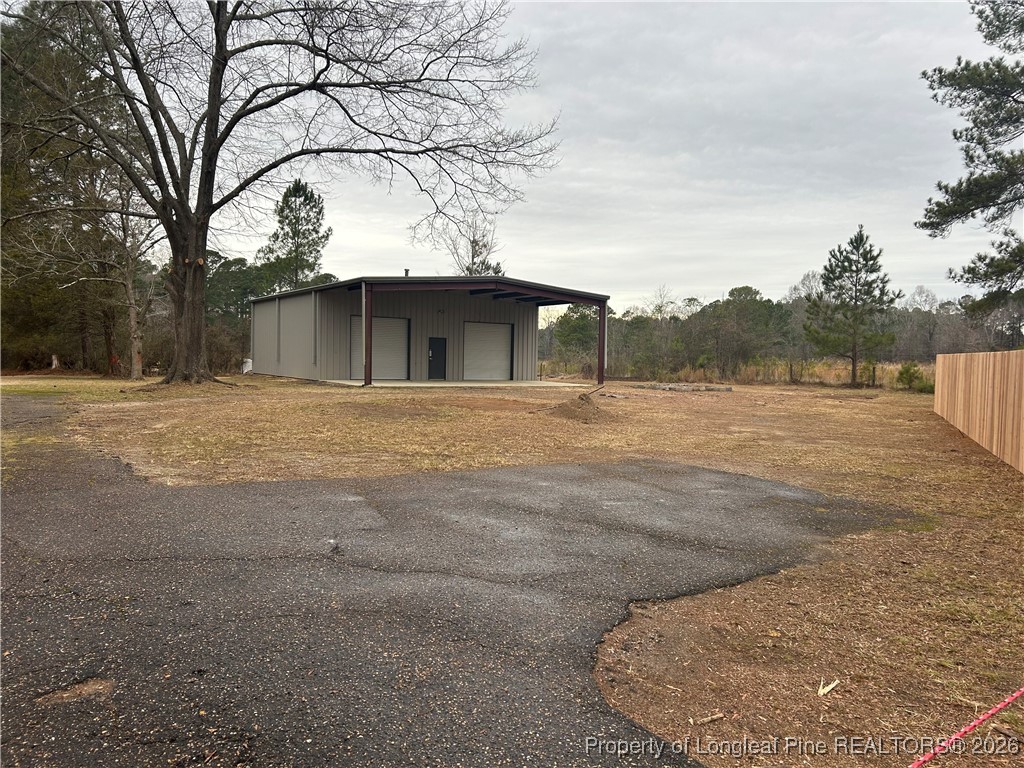 1700 Cedar Creek Road Fayetteville, NC 28312 - Photo 31 of 31 a backyard of a house with large trees and outdoor seating