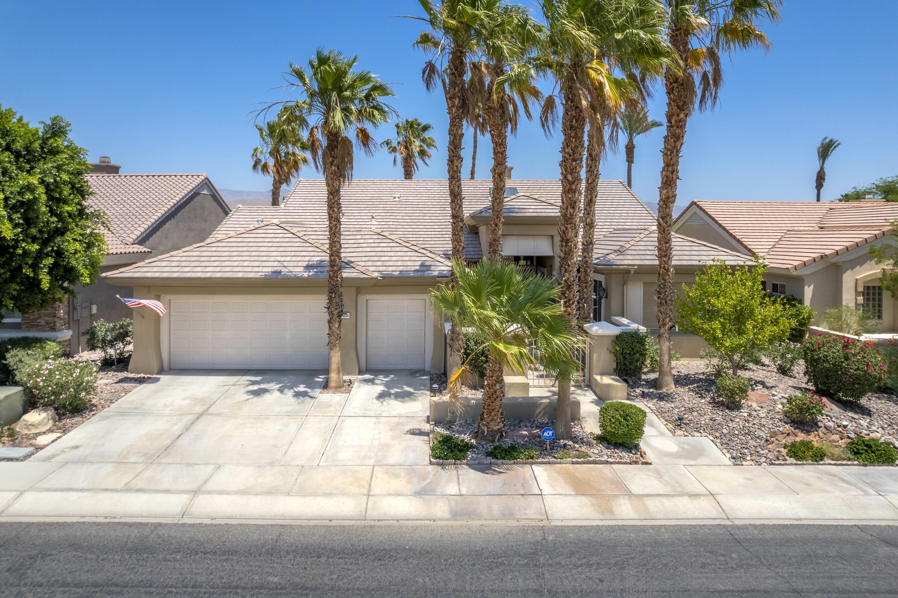 39623 Manorgate Road Palm Desert, CA 92211 - Photo 13 of 42 a palm tree sitting in front of a house with potted plants