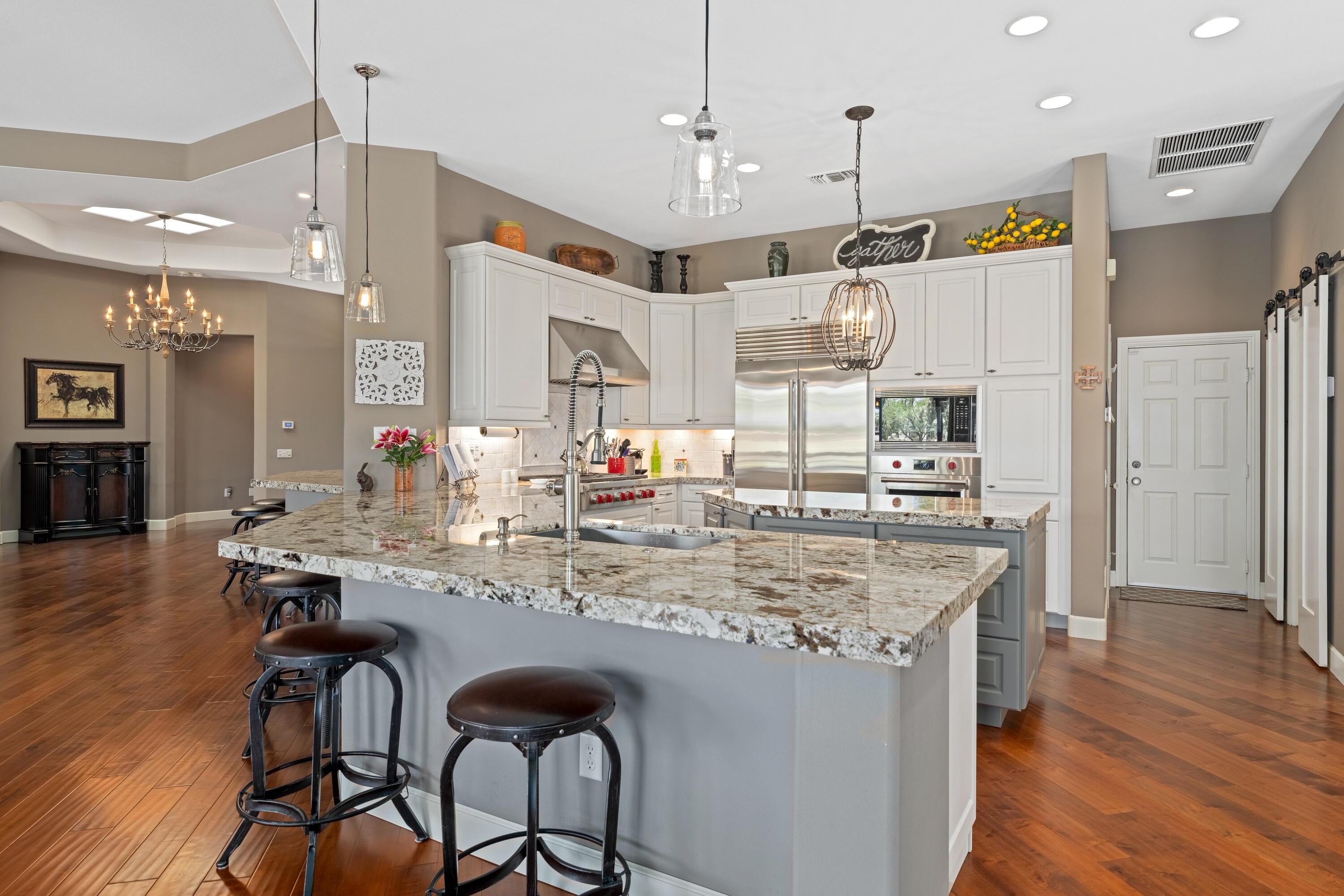39623 Manorgate Road Palm Desert, CA 92211 - Photo 22 of 42 a kitchen with stainless steel appliances kitchen island granite countertop a table chairs and a refrigerator