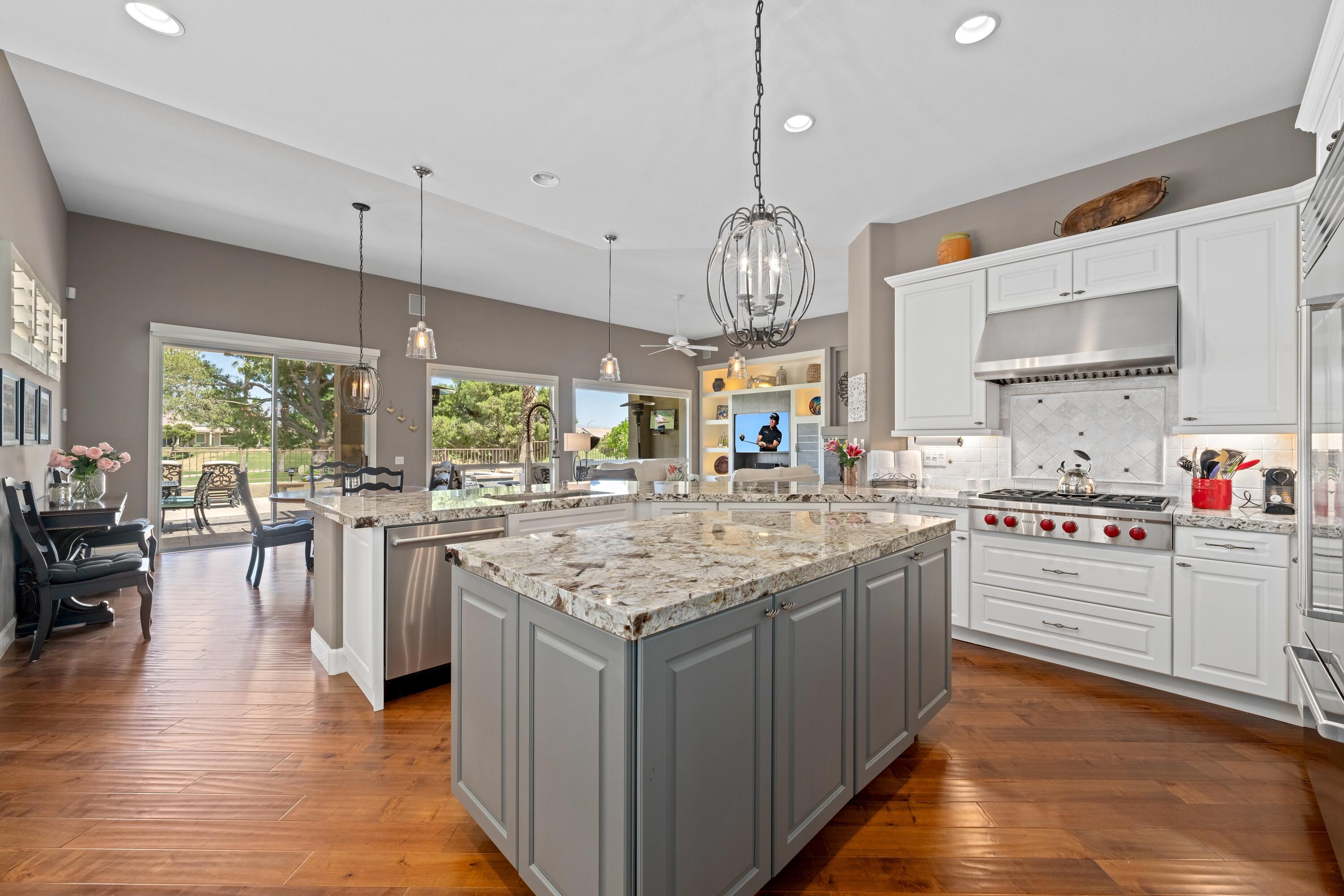 39623 Manorgate Road Palm Desert, CA 92211 - Photo 24 of 42 a kitchen with stainless steel appliances granite countertop wooden floors and white cabinets