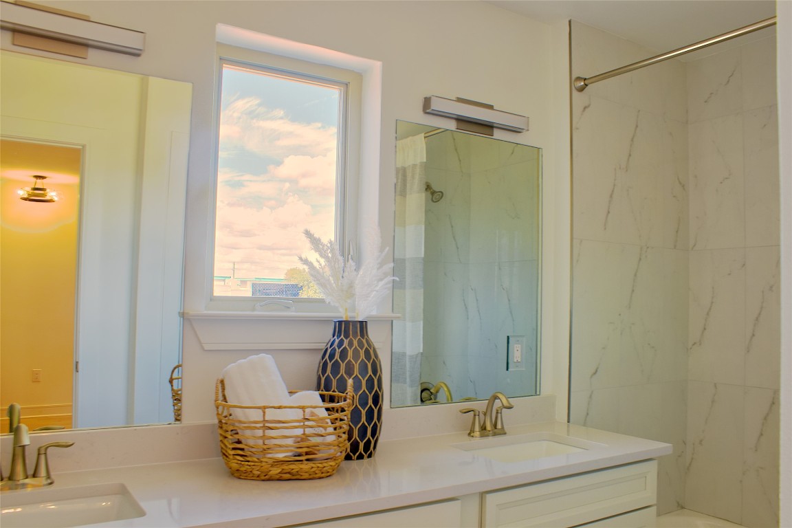 304 Tesla Circle Austin, TX 78681 - Photo 14 of 38 Bathroom with double vanity and a combined bath / shower with marble appearance