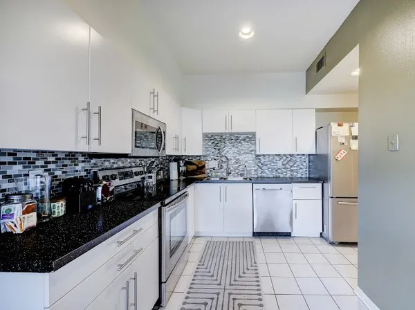 a kitchen with stainless steel appliances granite countertop a sink and cabinets