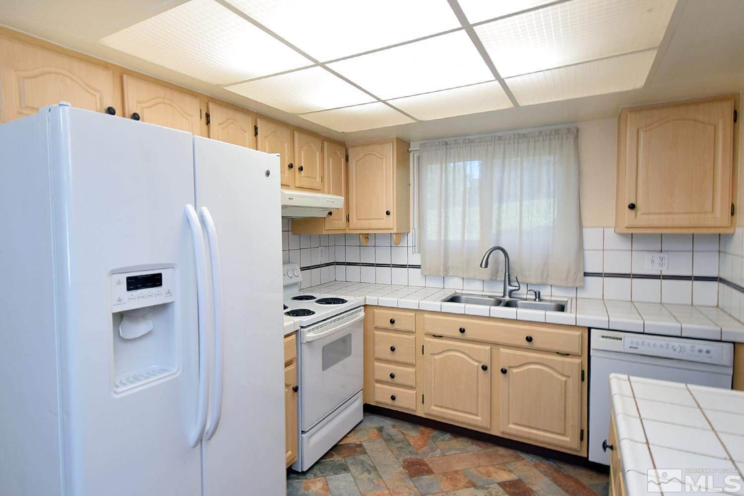 1113 Frontier Court Reno, NV 89503 - Photo 11 of 40 a kitchen with cabinets appliances a sink and a counter top