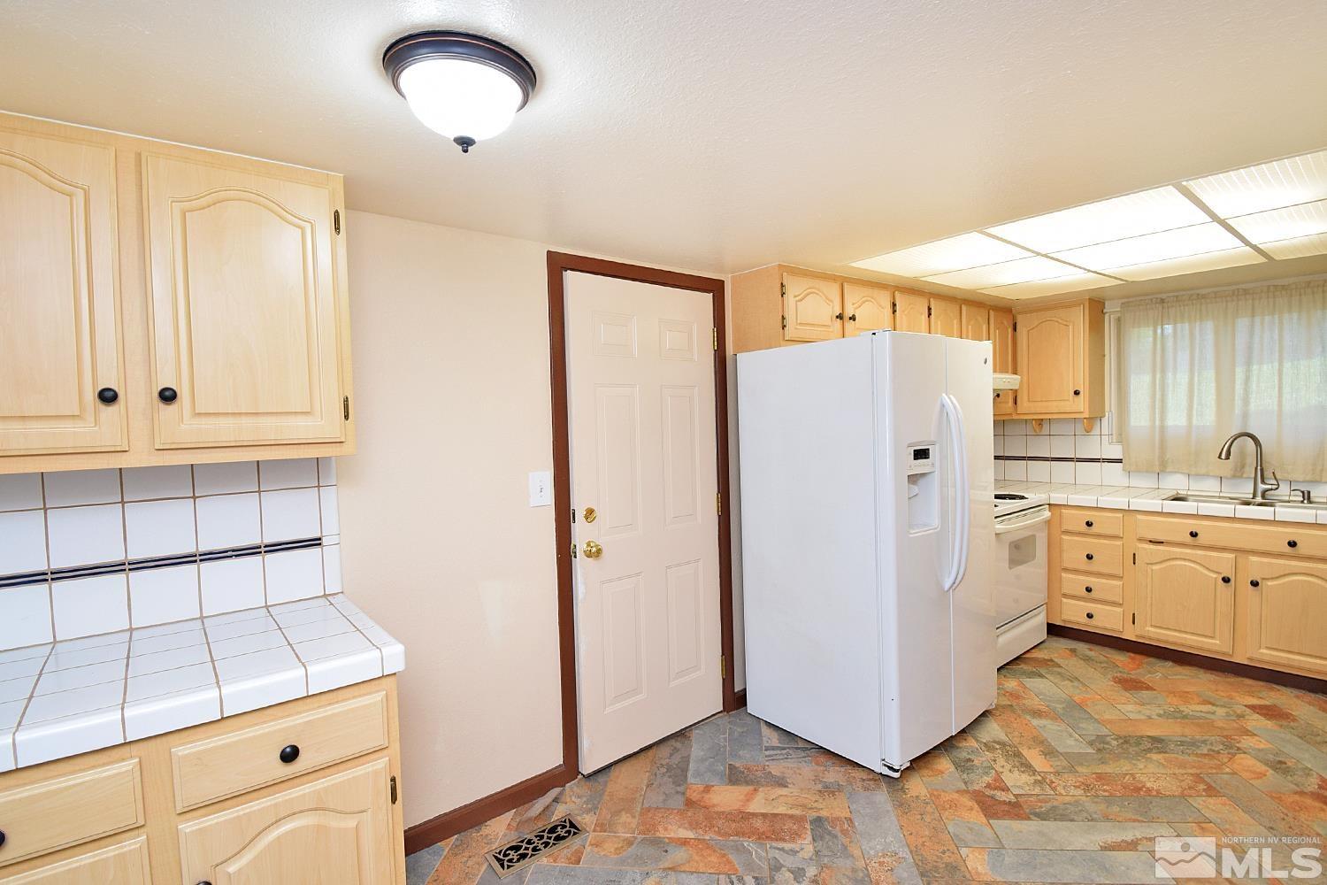 1113 Frontier Court Reno, NV 89503 - Photo 14 of 40 a kitchen with granite countertop cabinets and refrigerator