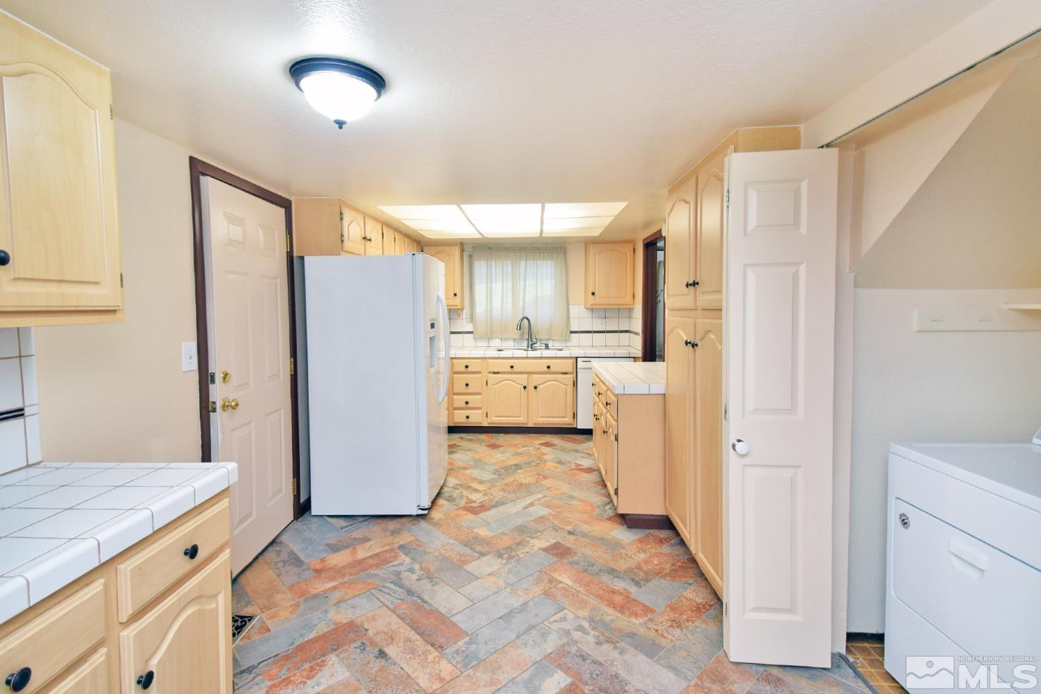1113 Frontier Court Reno, NV 89503 - Photo 15 of 40 a kitchen with a refrigerator a sink and cabinets