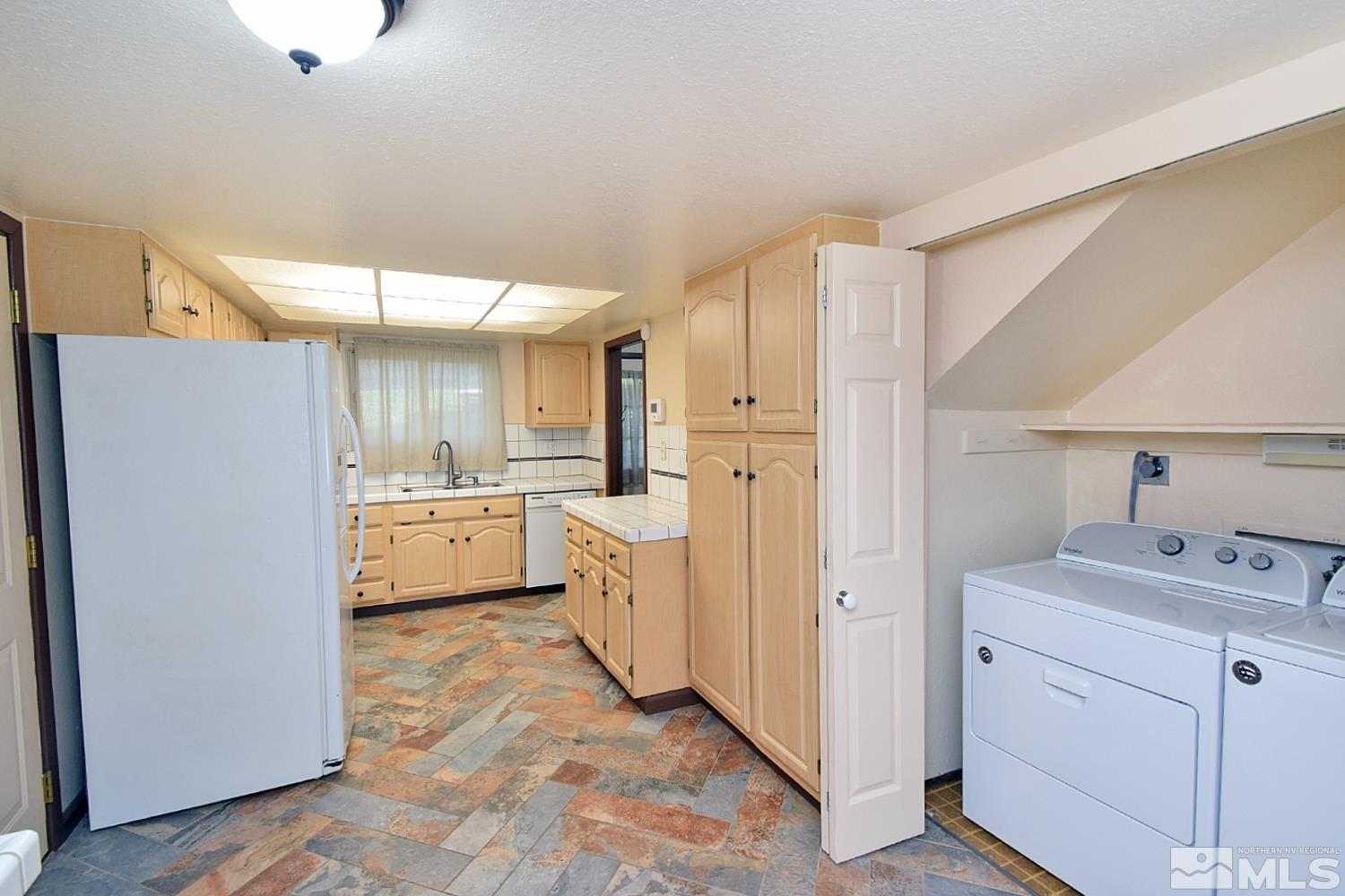 1113 Frontier Court Reno, NV 89503 - Photo 18 of 40 a kitchen with a sink a refrigerator and cabinets