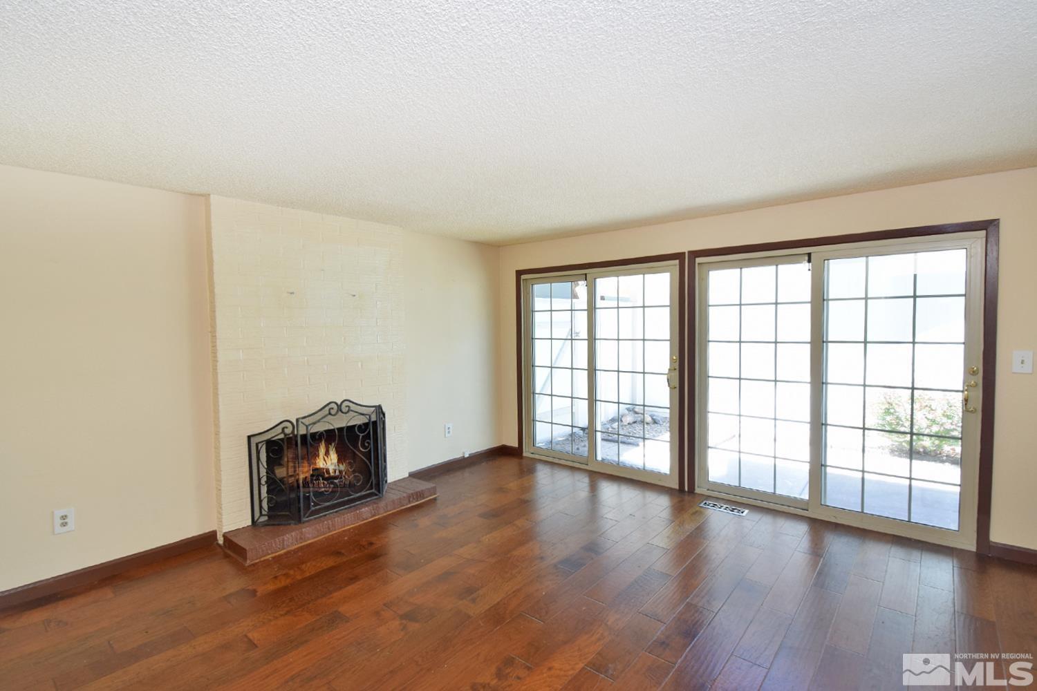 1113 Frontier Court Reno, NV 89503 - Photo 6 of 40 an empty room with wooden floor and fireplace