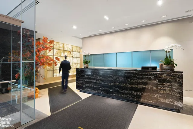 a view of swimming pool with outdoor seating and trees in the background