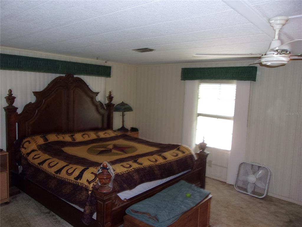 6485 Northeast 2nd Street Ocala, FL 34470 - Photo 32 of 55 a bed sitting in a bedroom next to a window