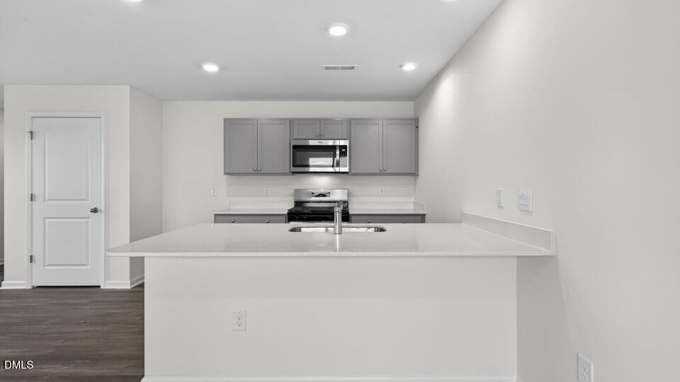 16 Red Clover Drive Angier, NC 27501 - Photo 11 of 36 a kitchen with kitchen island a sink a stove a microwave and a refrigerator