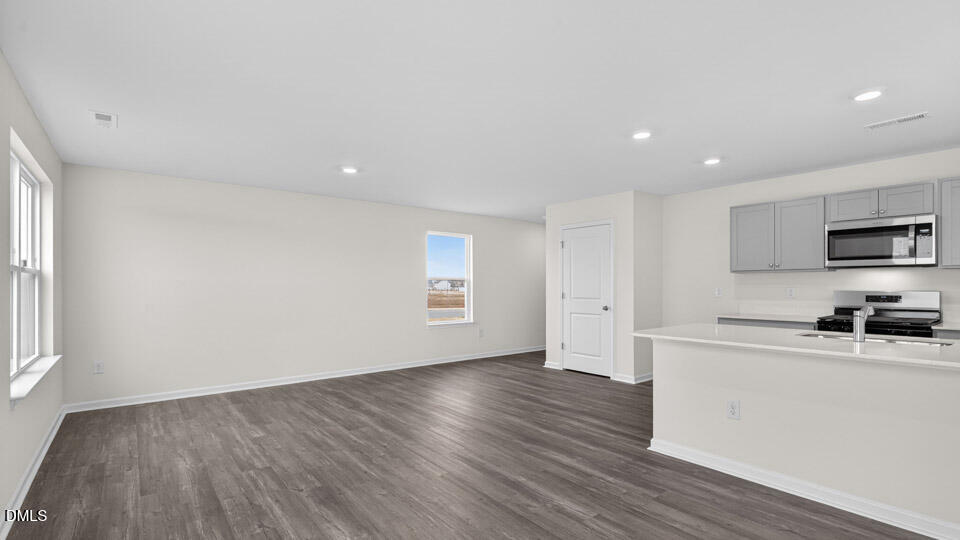 16 Red Clover Drive Angier, NC 27501 - Photo 13 of 36 a kitchen with a wooden floor a window and a stove