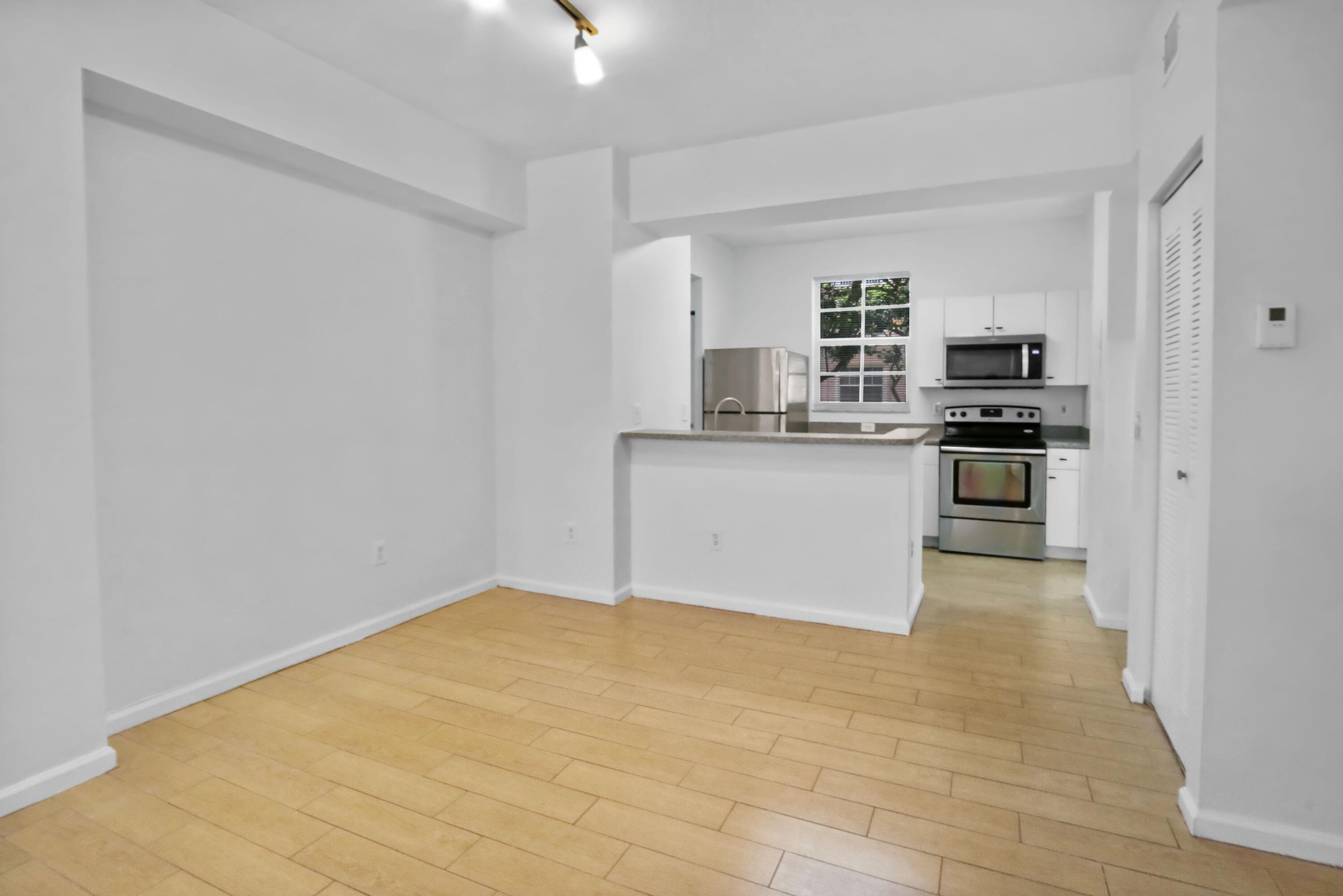 4784 Central Boulevard, Unit 10 Jupiter, FL 33458 - Photo 9 of 29 a kitchen with stainless steel appliances granite countertop a stove top oven a sink a counter space and cabinets