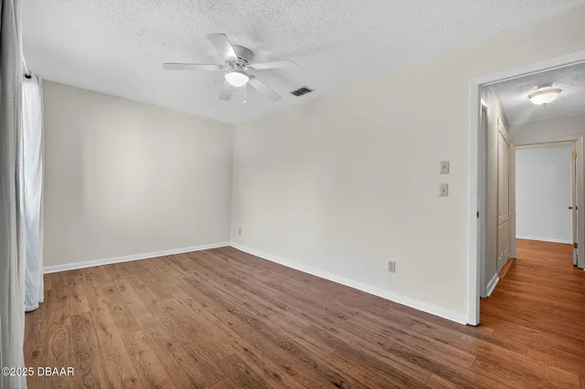 a view of an empty room with wooden floor