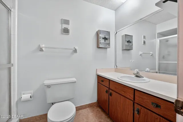 a bathroom with a granite countertop toilet sink and mirror