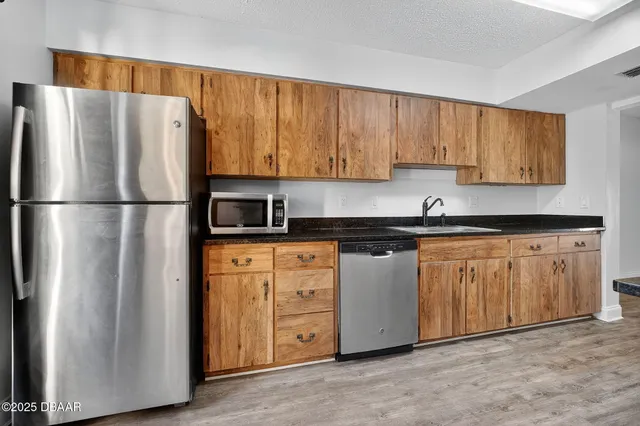 a kitchen with stainless steel appliances granite countertop a refrigerator sink and cabinets