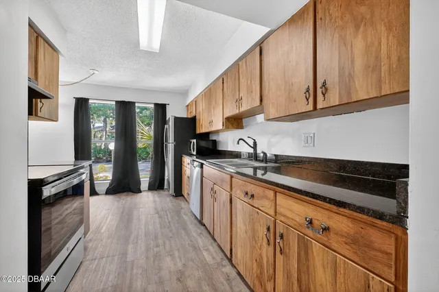 a kitchen with granite countertop a sink stove and cabinets