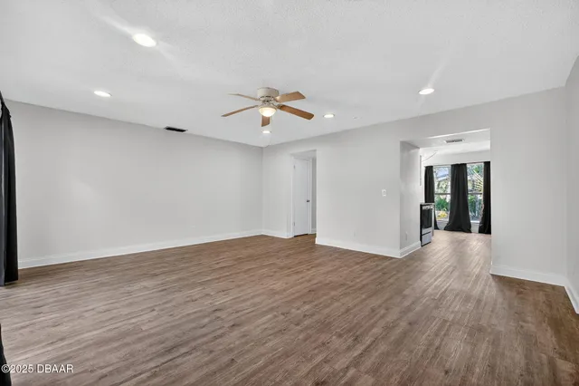 a view of a room with wooden floor and ceiling fan