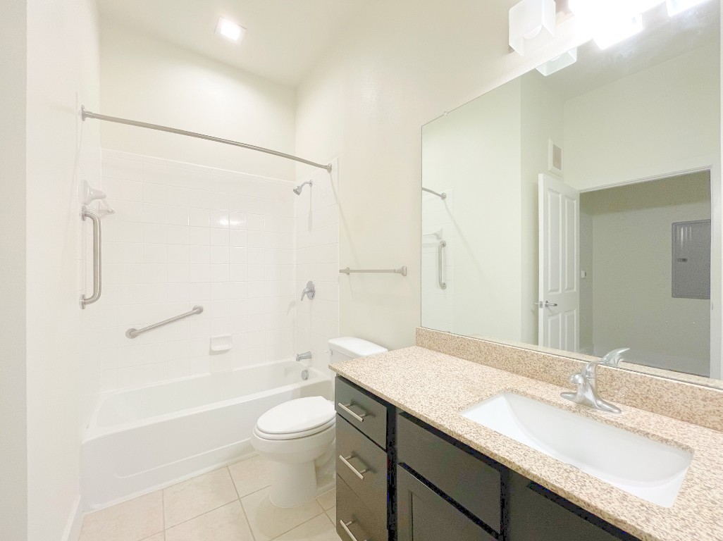 2400 Louis Henna Boulevard, Unit 103 Round Rock, TX 78664 - Photo 14 of 22 a bathroom with a granite countertop sink toilet a shower and a mirror